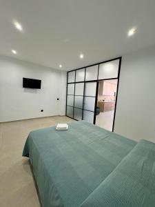 a bedroom with a green bed and a flat screen tv at Las Casas Del Puente in Córdoba