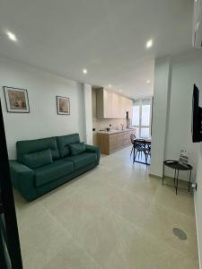 a living room with a green couch and a kitchen at Las Casas Del Puente in Córdoba