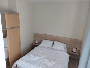 a bedroom with a bed with white sheets and pillows at Apartments Lafranconi in Bratislava