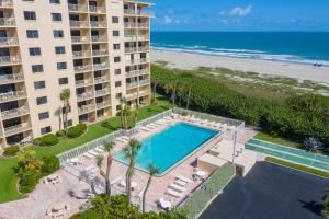 an aerial view of a hotel with a swimming pool and the beach at Canaveral Towers in Cape Canaveral