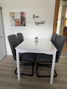 a white table and chairs with a sign that reads born expert at Ferienwohnung Dammer in Niederkrüchten