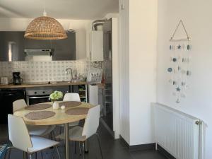 a kitchen with a table and chairs in a kitchen at Superbe appartement, vue imprenable sur le port in Audierne