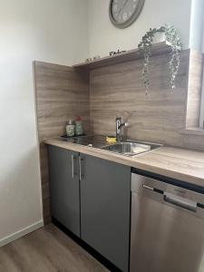 a kitchen with a sink and a clock on the wall at Ferienwohnung Dammer in Niederkrüchten