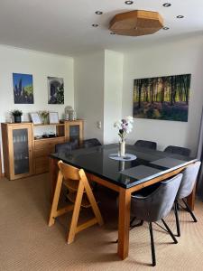 a dining room with a black table and chairs at Ferienwohnung Dammer in Niederkrüchten