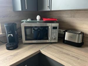 a microwave sitting on top of a counter with a coffee maker at Ferienwohnung Dammer in Niederkrüchten