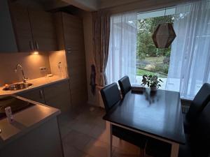 uma cozinha com mesa e cadeiras e uma janela em Ruhiger Bungalow Nr 156 "Haus Gezellig" Strandnah mit großen, uneinsehbaren Garten, am Ende des Parks, sehr ruhig em Sint Maartenszee