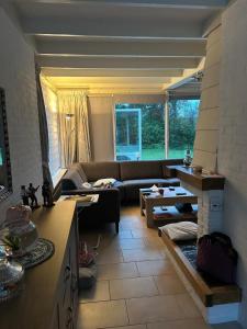 uma sala de estar com um sofá e uma mesa em Ruhiger Bungalow Nr 156 "Haus Gezellig" Strandnah mit großen, uneinsehbaren Garten, am Ende des Parks, sehr ruhig em Sint Maartenszee mais 20 fotografias