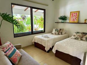 a room with two beds and a couch and a window at Espectacular finca cerca a Buga in Guacarí