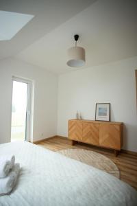 塞尔纳珀苏马维Útulný apartmán s výhledem na Lipno的白色卧室配有床和木制梳妆台