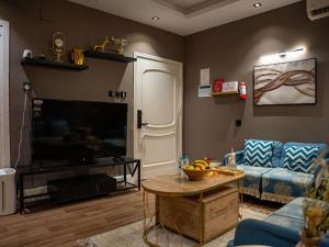 a living room with a blue couch and a tv at شقة فندقية غرفتين وصالة in Al Madinah