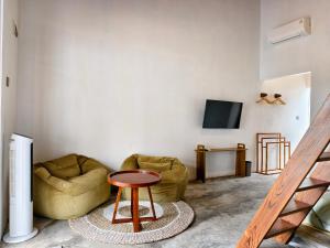 a living room with two chairs and a table at Sadi Beach House in Telukbakau