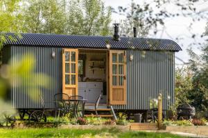 ein kleines Haus in einem Garten mit einem Tisch und Stühlen in der Unterkunft Peatlands Retreat, Causeway Coast in Ballybogy
