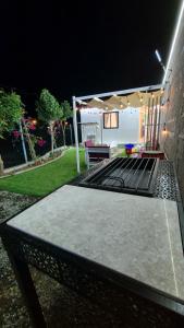 una mesa de ping pong en el patio trasero por la noche en Chalet-JS-شاليه, en Hatta