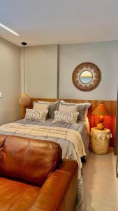 a bedroom with a large bed with a leather couch at Estúdio 908: conforto e sofisticação no coração de Jardim Camburi in Vitória +53 photos