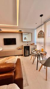 a living room with a couch and a table at Estúdio 908: conforto e sofisticação no coração de Jardim Camburi in Vitória