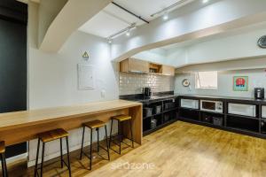 eine Küche mit einer langen Theke und Stühlen in der Unterkunft Estúdios no Centro Histórico de Poa - ELSs in Porto Alegre