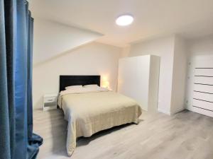 a bedroom with a bed in a white room at Modern 2023 apartment in Kutno