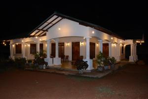 a white house with plants in front of it at night at First House Mihintale in Mihintale