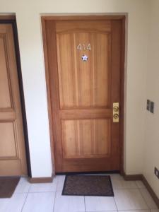 a wooden door with the number on it at Departamento papudo Valparaíso in Papudo