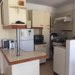 a kitchen with a white refrigerator and a counter top at Departamento papudo Valparaíso in Papudo