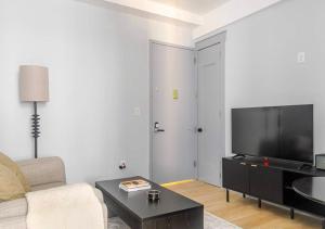 a living room with a couch and a flat screen tv at Midtown West 2 Bedroom Furnished Apartment Rental in New York