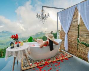 a girl sitting in a bath tub with a view at Naraview at phuchifa in Thoeng +63 photos