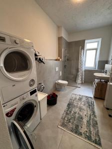 a bathroom with a washer and dryer in it at Aby Wohnungen in Rosenheim