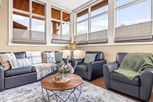 a living room with two couches and a table at Cozy 2BR Retreat Mountain View with Pool and Hot Tub in Canmore