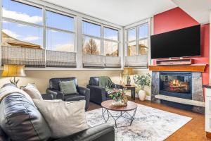 a living room with a fireplace and a tv at Cozy 2BR Retreat Mountain View with Pool and Hot Tub in Canmore