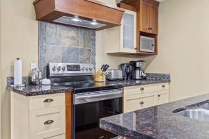 eine Küche mit Herd oberer Ofen neben einer Spüle in der Unterkunft Spacious Rockies Escape near Banff Hot tub and Gym in Canmore