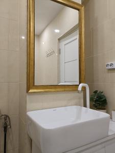 a bathroom with a white sink and a mirror at The Friendly Apartment in Turda