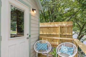 a porch with two chairs and a door at River Run - Riverfront Tiny Home, Trails, and Views! in Sylva