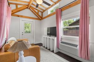 a living room with a large window and a television at River Run - Riverfront Tiny Home, Trails, and Views! in Sylva +13 photos