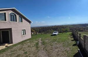 ein Auto, das auf einem Hof neben einem Haus parkt in der Unterkunft Qusarda günlük ev in Qusar