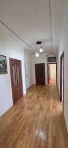 ein leerer Raum mit Holzboden und Holztüren in der Unterkunft Qusarda günlük ev in Qusar