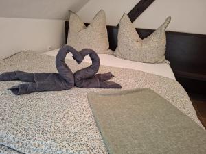 two towels in the shape of a heart on a bed at Apartmán Coralina in Zvolen
