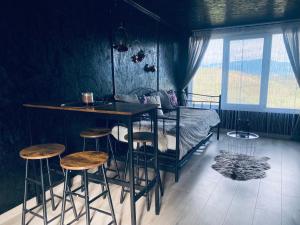 a bedroom with a bed and a bar with stools at Panorama Lupilor in Coleşti