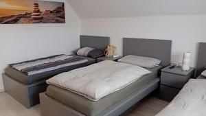 a room with two beds and two night stands at FeWo "LaVida" Papenburg in Papenburg