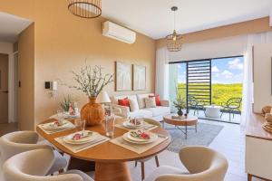 a living room with a table and chairs and a couch at Elegant 3BR Condo Near Airport in Punta Cana