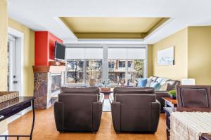a living room with a couch and a fireplace at Exciting Rockies 1BR Escape with Hot Tub, Pool and BBQ in Canmore
