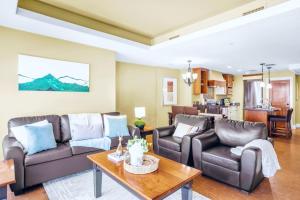 a living room with leather couches and a table at Exciting Rockies 1BR Escape with Hot Tub, Pool and BBQ in Canmore