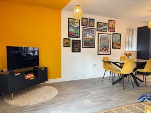 a living room with a tv and a table and chairs at 4BR - 3BA - Fast Wi-Fi - Free Parking - Garden - EV Point in Horsham