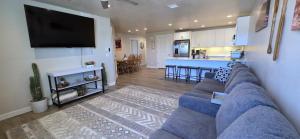 a living room with a blue couch and a kitchen at Hot Tub, Kayaks, Game Room, Boat Parking, Fire Pit, King, WD in Page