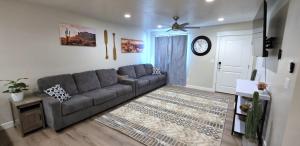 a living room with a couch and a clock on the wall at Hot Tub, Kayaks, Game Room, Boat Parking, Fire Pit, King, WD in Page