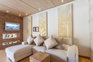 a living room with a white couch and a table at Dhevan Dara Resort & Spa Hua Hin - Pool Villa in Hua Hin