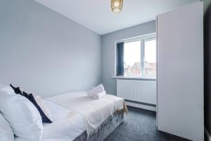 une chambre blanche avec un lit et une fenêtre dans l'établissement Spacious 3-BR Escape in Coseley with Free Parking, à Coseley