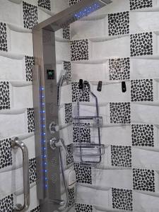 a bathroom with a shower with black and white tiles at Seckebe Immo Studio Vert in Dakar +27 photos