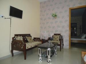 a living room with two chairs and a table at Muscat Holiday Resort in Cox's Bazar