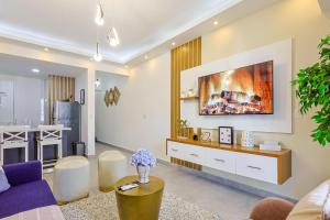 a living room with a couch and a kitchen at Cozy 1BR Condo, Pool, Gym in Ensanche Quisqueya