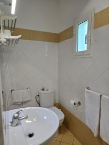 a bathroom with a sink and a toilet and a window at Soul of Sal in Santa Maria +11 photos
